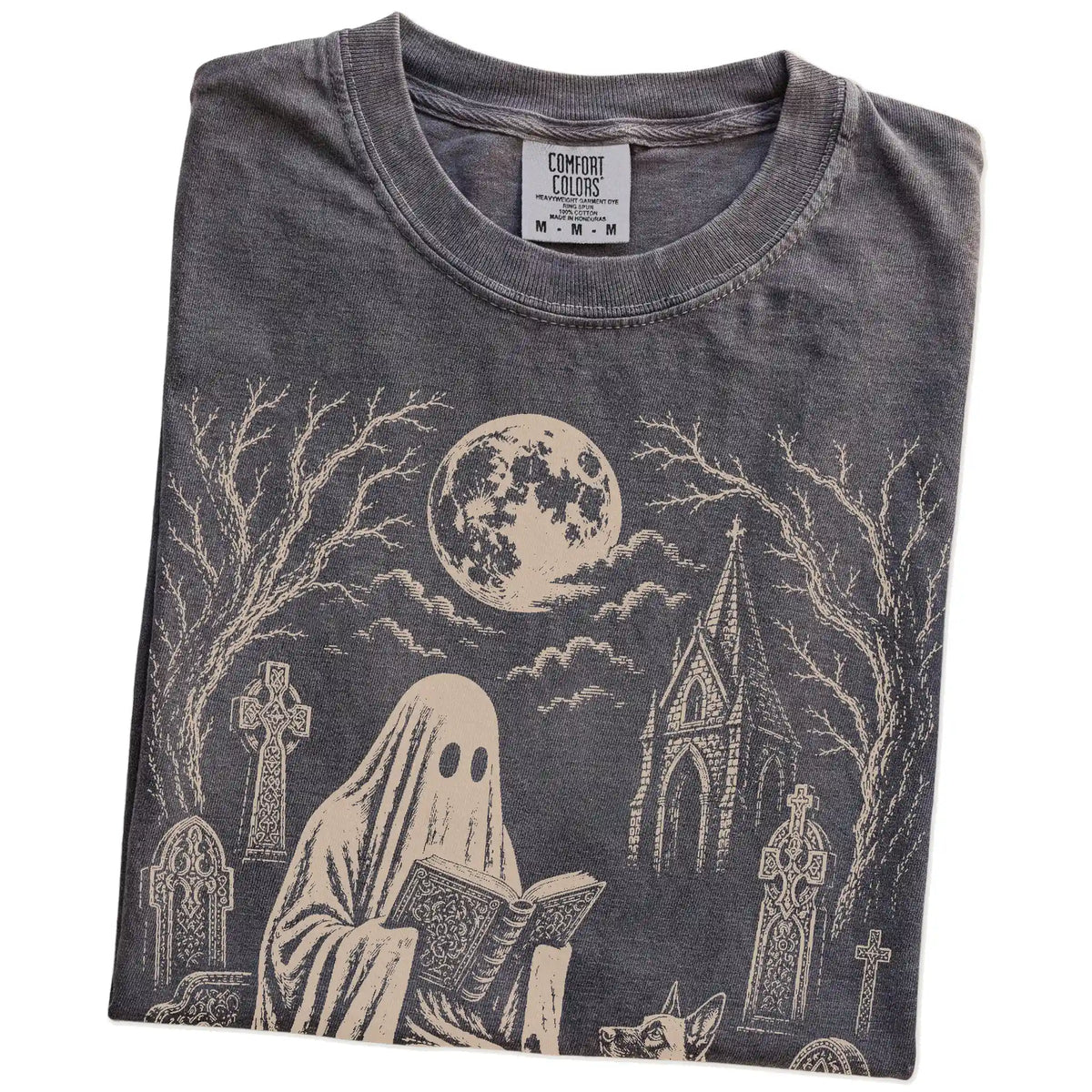 Folded Pepper Comfort Colors® T-shirt showing Belgian Malinois beside a reading ghost in a moonlit graveyard