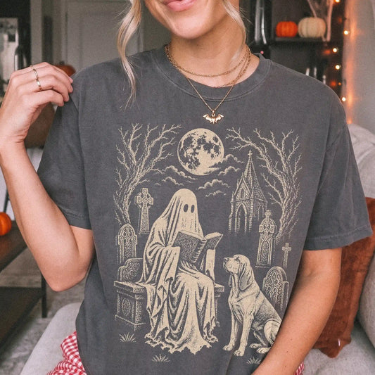 Model wearing a Pepper Comfort Colors® T-shirt showing Bloodhound beside a reading ghost in a moonlit graveyard