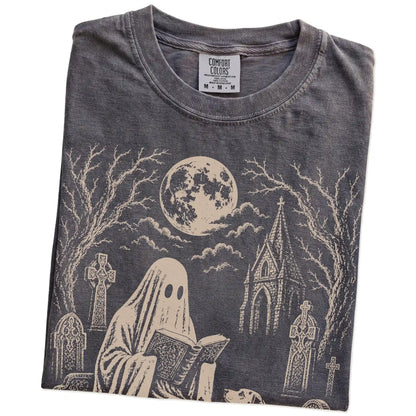 Folded Pepper Comfort Colors® T-shirt showing Dalmatian beside a reading ghost in a moonlit graveyard