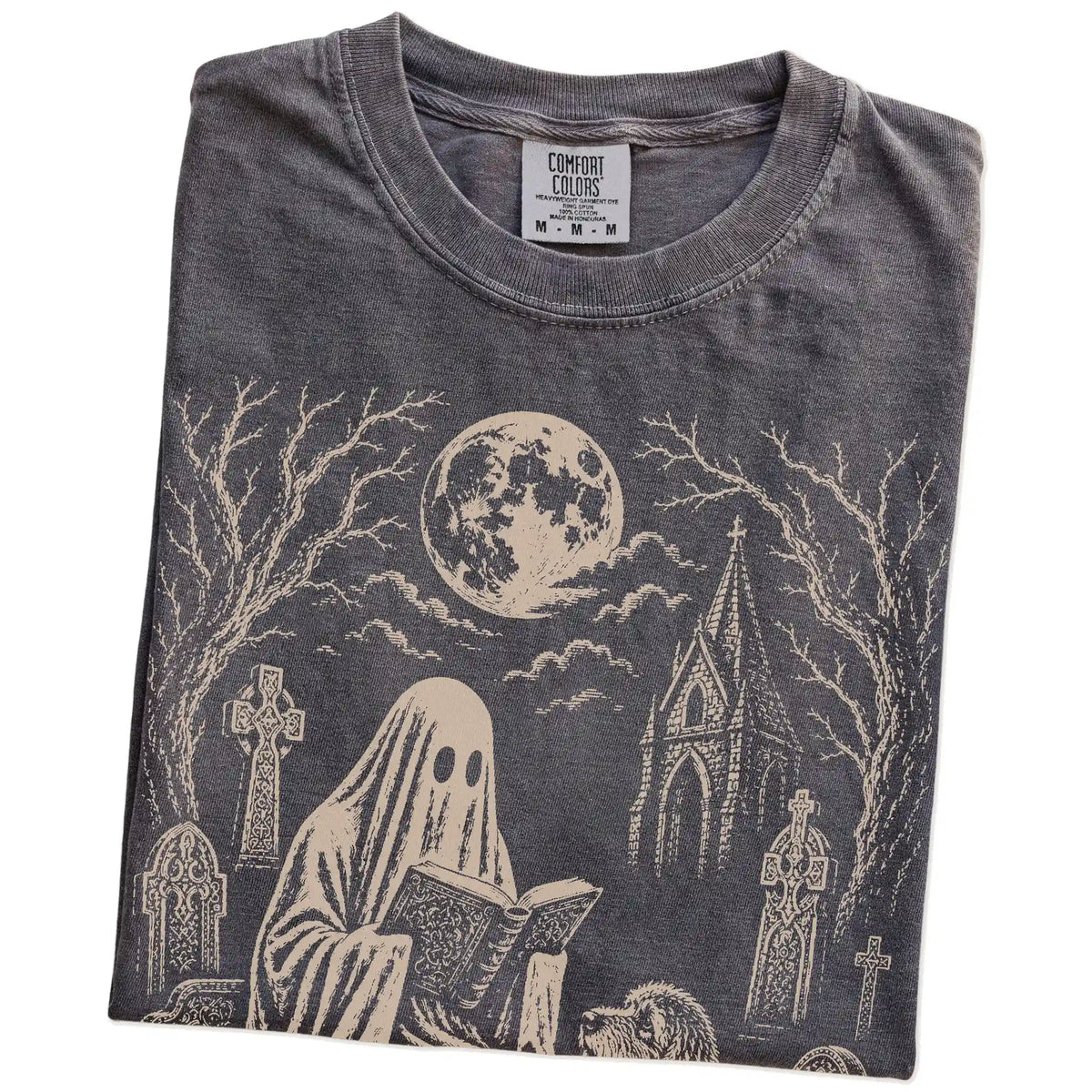 Folded Pepper Comfort Colors® T-shirt showing Goldendoodle beside a reading ghost in a moonlit graveyard