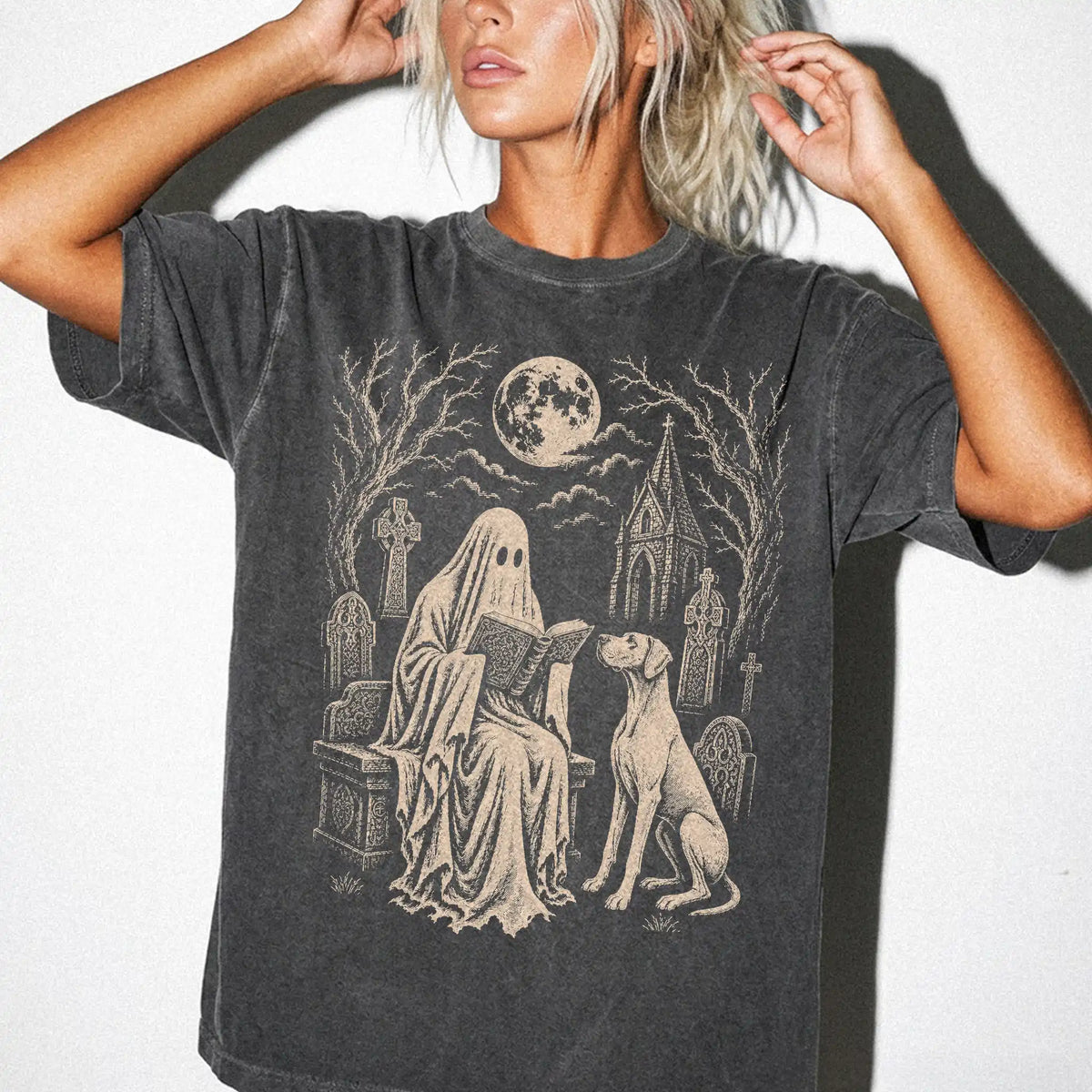 Model wearing a Pepper Comfort Colors® T-shirt showing Great Dane beside a reading ghost in a moonlit graveyard