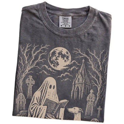 Folded Pepper Comfort Colors® T-shirt showing Greyhound beside a reading ghost in a moonlit graveyard