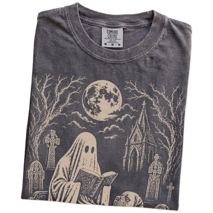 Folded Pepper Comfort Colors® T-shirt showing Mastiff beside a reading ghost in a moonlit graveyard