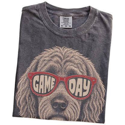 Folded Pepper Comfort Colors® T-shirt showing goldendoodle wearing red game day sunglasses
