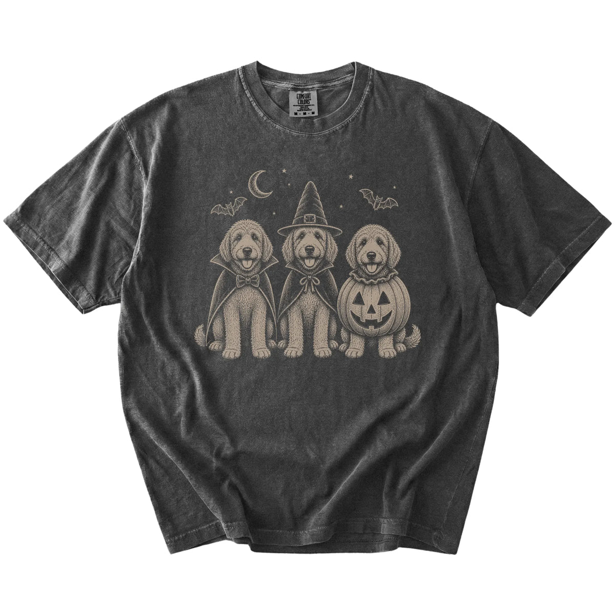 Three Goldendoodle dogs dressed for Halloween beneath bats and a crescent moon on a Pepper Comfort Colors® T-shirt