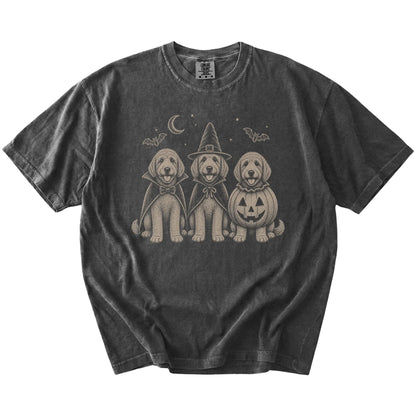 Three Goldendoodle dogs dressed for Halloween beneath bats and a crescent moon on a Pepper Comfort Colors® T-shirt