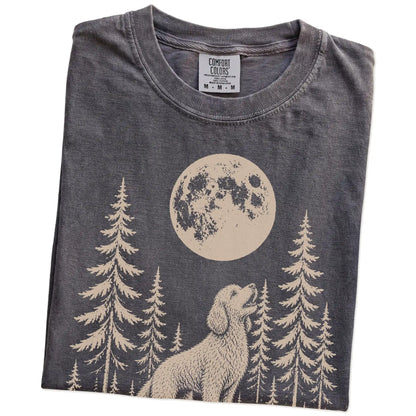 Folded Pepper Comfort Colors® T-shirt showing a Goldendoodle howling beneath the moon and pine trees