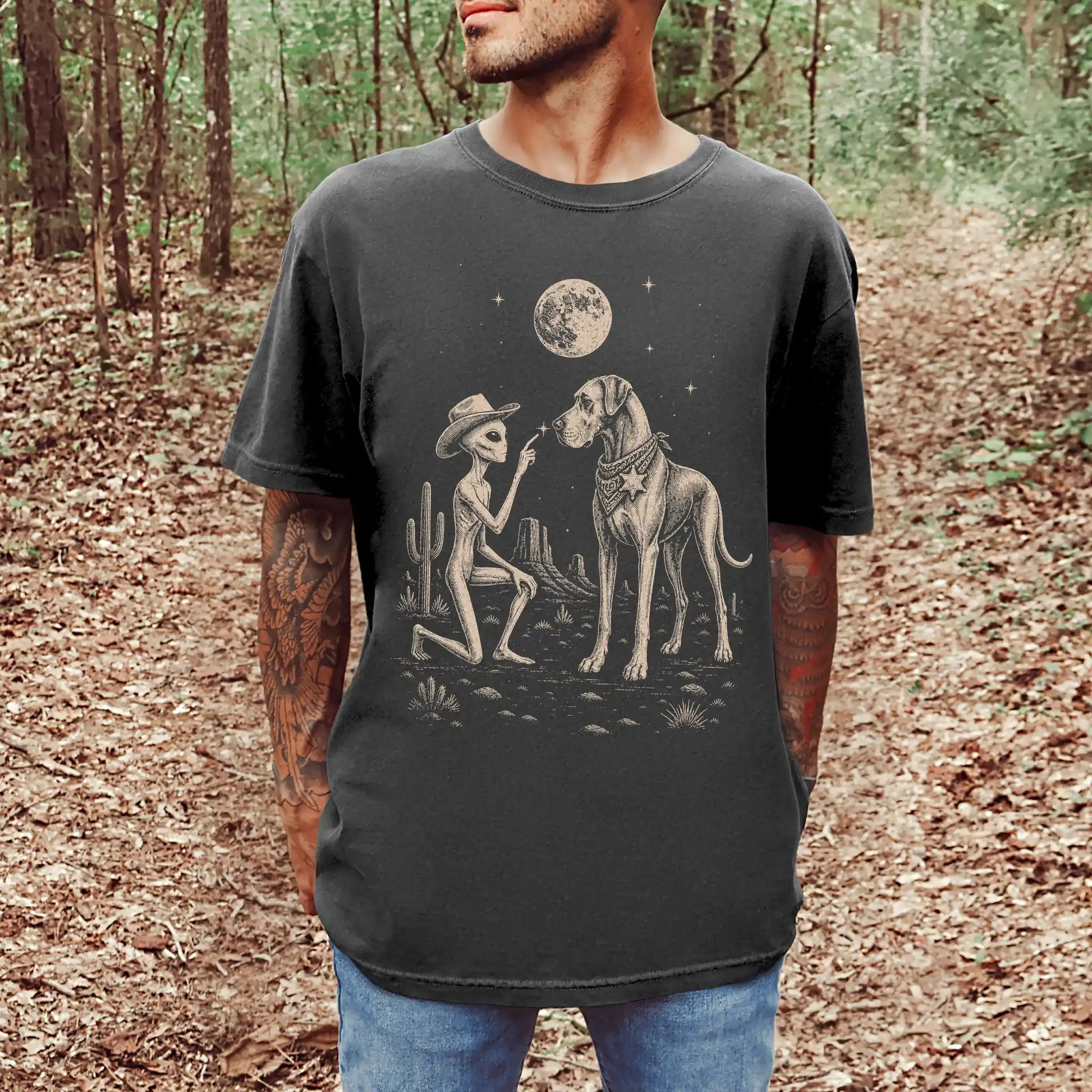 Model wearing a Pepper Comfort Colors® T-shirt with cowboy alien fist-bumping a great dane beneath the moon