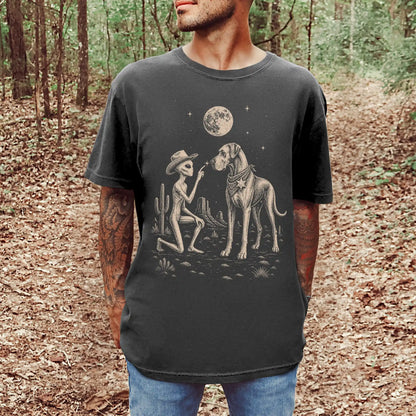 Model wearing a Pepper Comfort Colors® T-shirt with cowboy alien fist-bumping a great dane beneath the moon