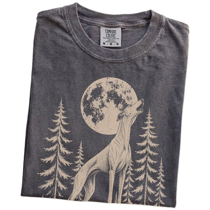Folded Pepper Comfort Colors® T-shirt showing a Greyhound howling beneath the moon and pine trees