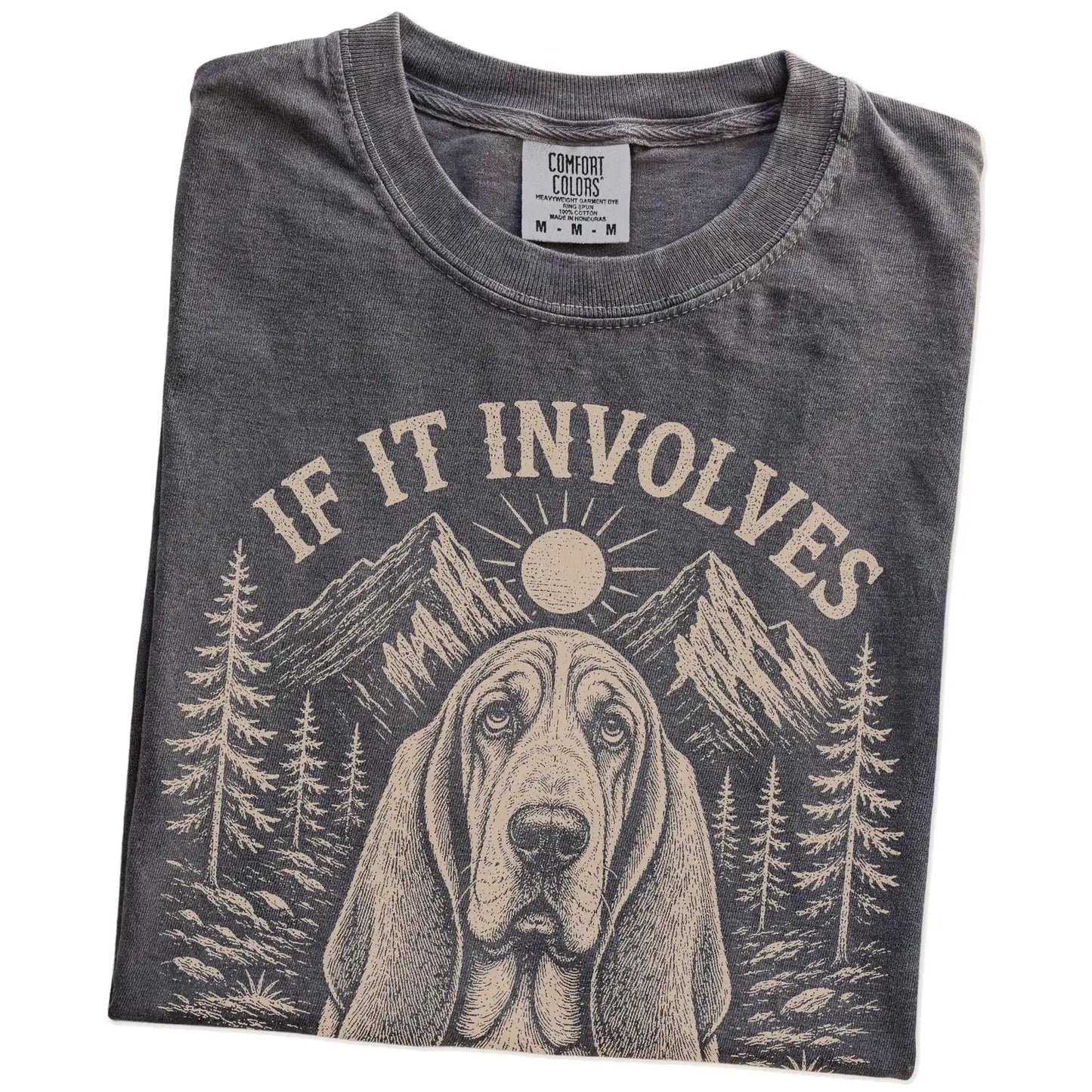 Folded Pepper Comfort Colors® T-shirt showing Basset Hound hiking design with mountain scenery