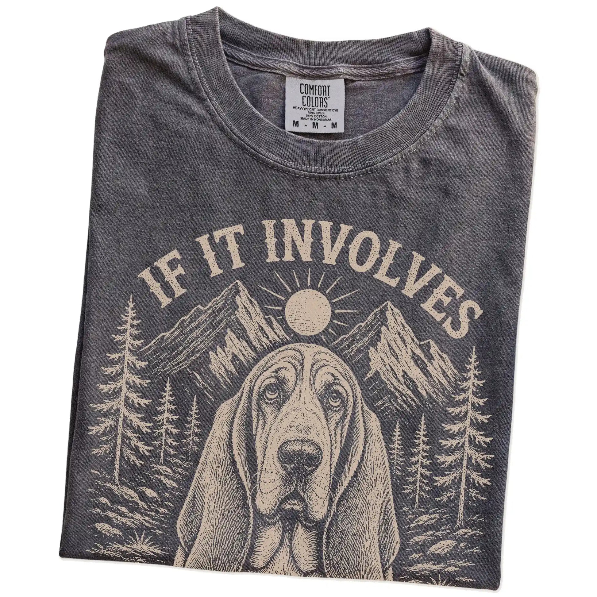 Folded Pepper Comfort Colors® T-shirt showing Basset Hound hiking design with mountain scenery