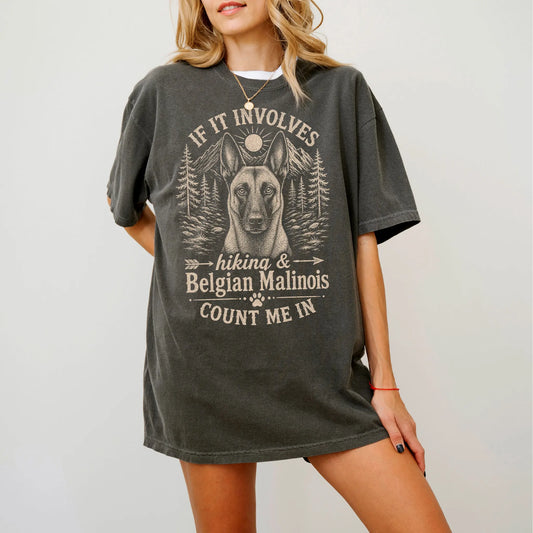 Model wearing a Pepper Comfort Colors® T-shirt featuring Belgian Malinois hiking design with mountain scenery