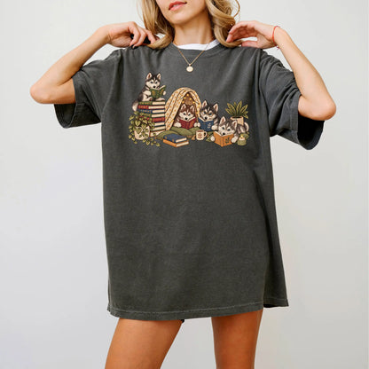 Husky puppies reading books in a cozy blanket fort on a Pepper T-shirt worn by a model