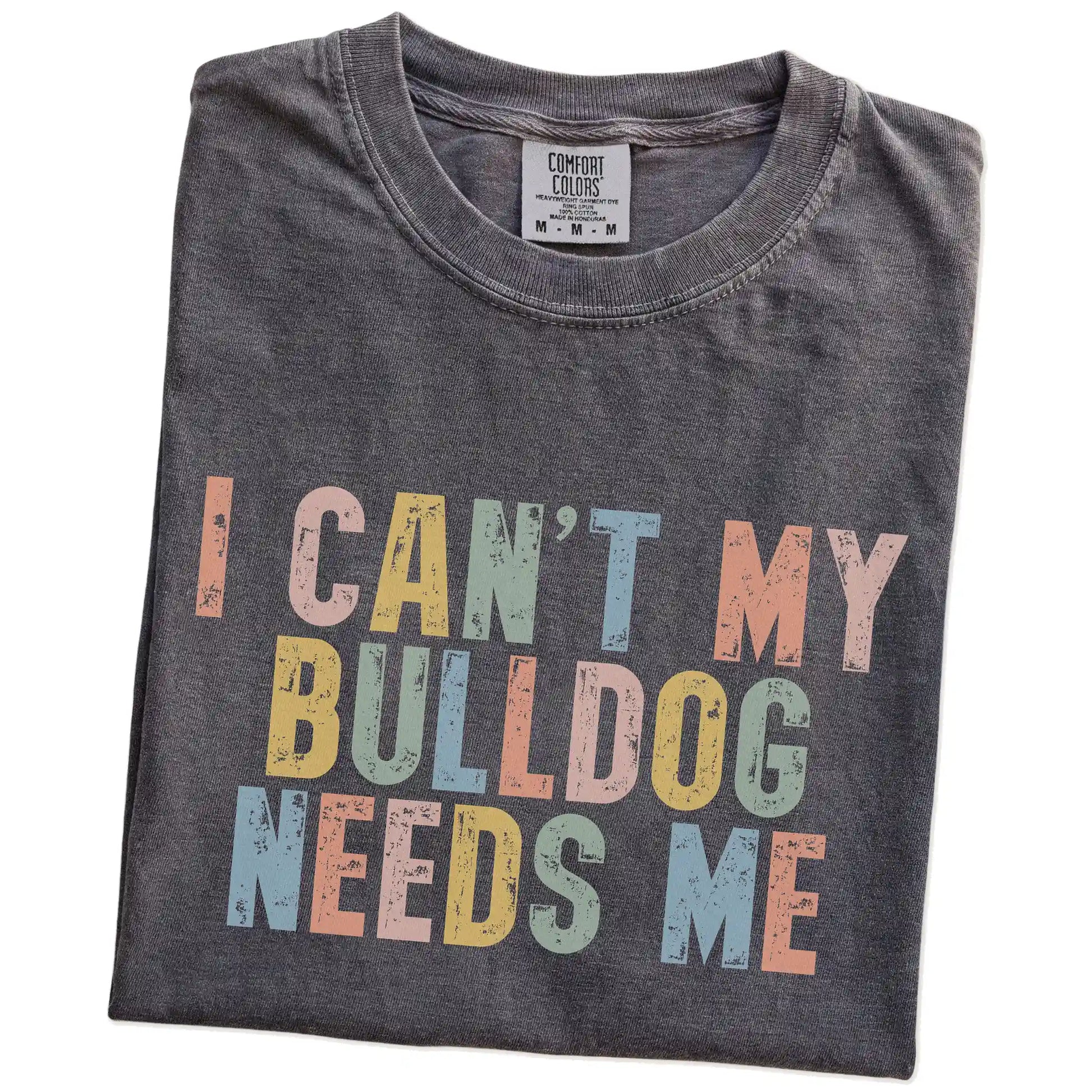 Folded Pepper Comfort Colors® T-shirt showing Bulldog with “I Can’t, My Dog Needs Me” lettering