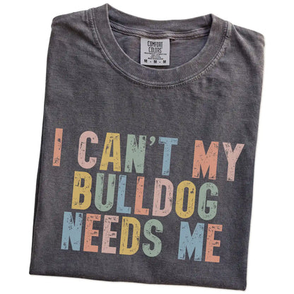 Folded Pepper Comfort Colors® T-shirt showing Bulldog with “I Can’t, My Dog Needs Me” lettering