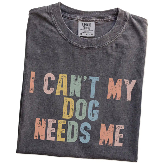 Folded Pepper Comfort Colors® T-shirt showing dogs with “I Can’t, My Dog Needs Me” lettering
