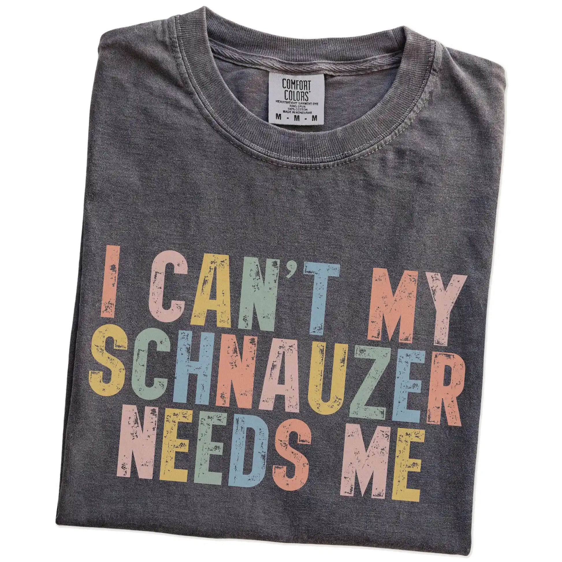 Folded Pepper Comfort Colors® T-shirt showing Schnauzer with “I Can’t, My Dog Needs Me” lettering