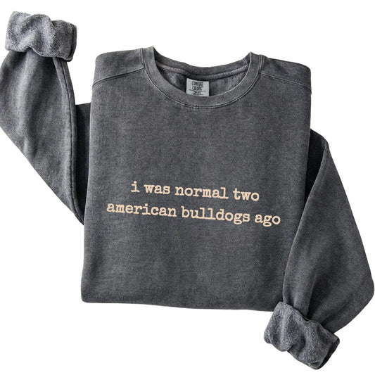 Pepper I Was Normal Two American Bulldogs Ago Comfort Colors sweatshirt folded to show the printed design