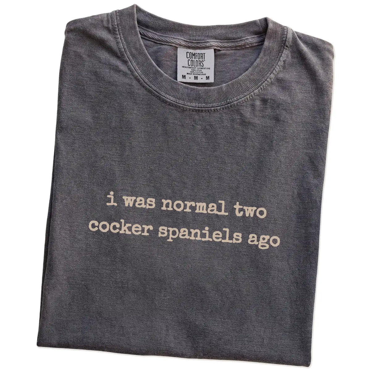 Folded Pepper Comfort Colors® T-shirt showing i was normal two cocker spaniels ago lettering