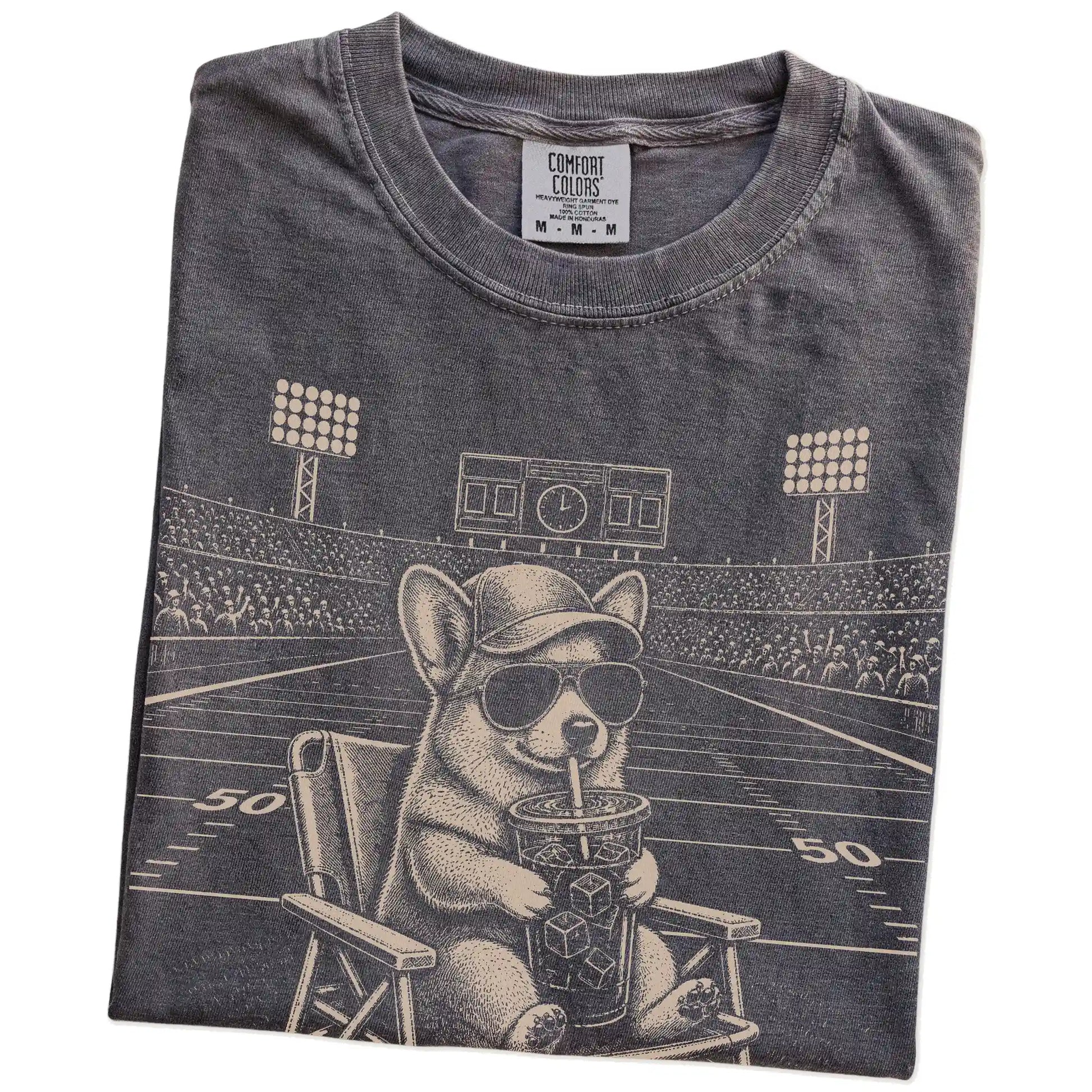 Folded Pepper Comfort Colors® T-shirt showing Corgi claiming the football field with “I Live Here Now” lettering