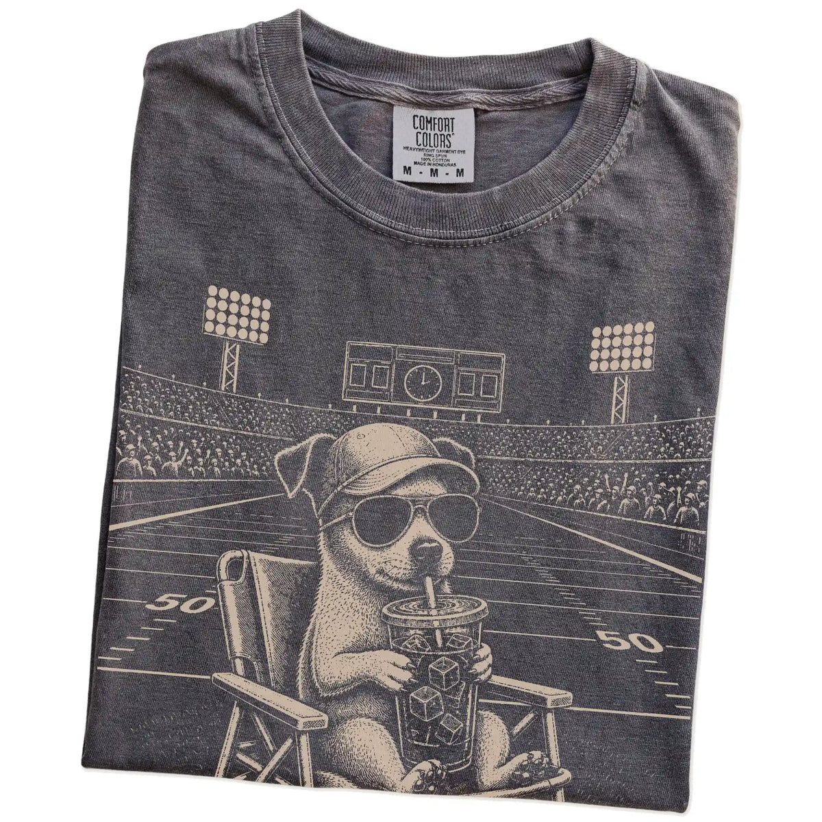 Folded Pepper Comfort Colors® T-shirt showing Jack Russell claiming the football field with “I Live Here Now” lettering