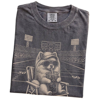 Folded Pepper Comfort Colors® T-shirt showing Pomeranian claiming the football field with “I Live Here Now” lettering