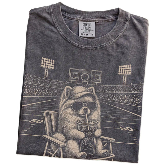 Folded Pepper Comfort Colors® T-shirt showing Pomeranian claiming the football field with “I Live Here Now” lettering
