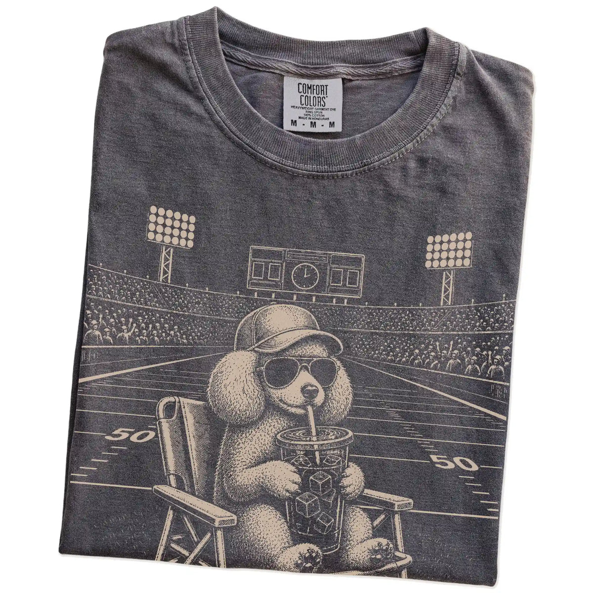 Folded Pepper Comfort Colors® T-shirt showing Poodle claiming the football field with “I Live Here Now” lettering
