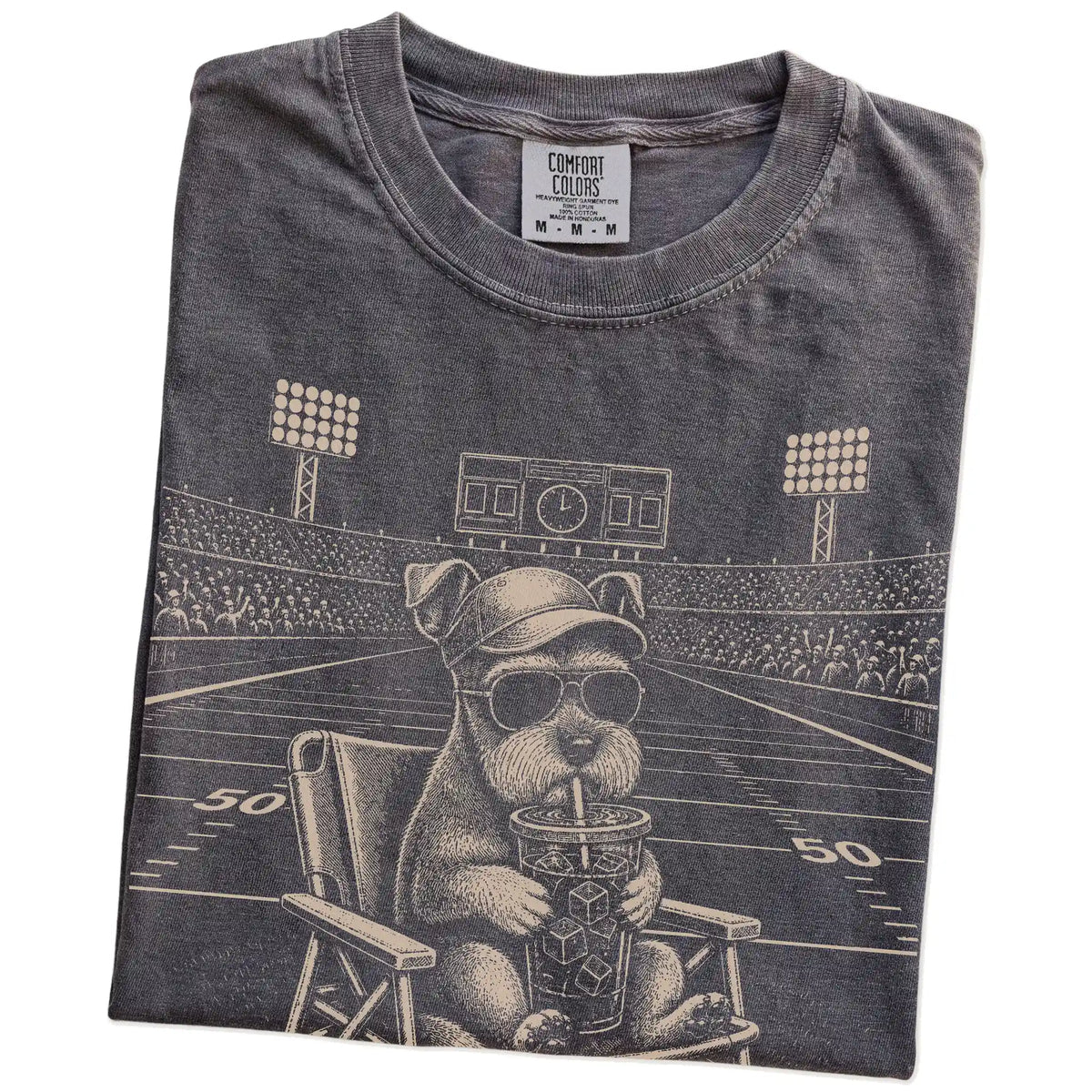 Folded Pepper Comfort Colors® T-shirt showing Schnauzer claiming the football field with “I Live Here Now” lettering