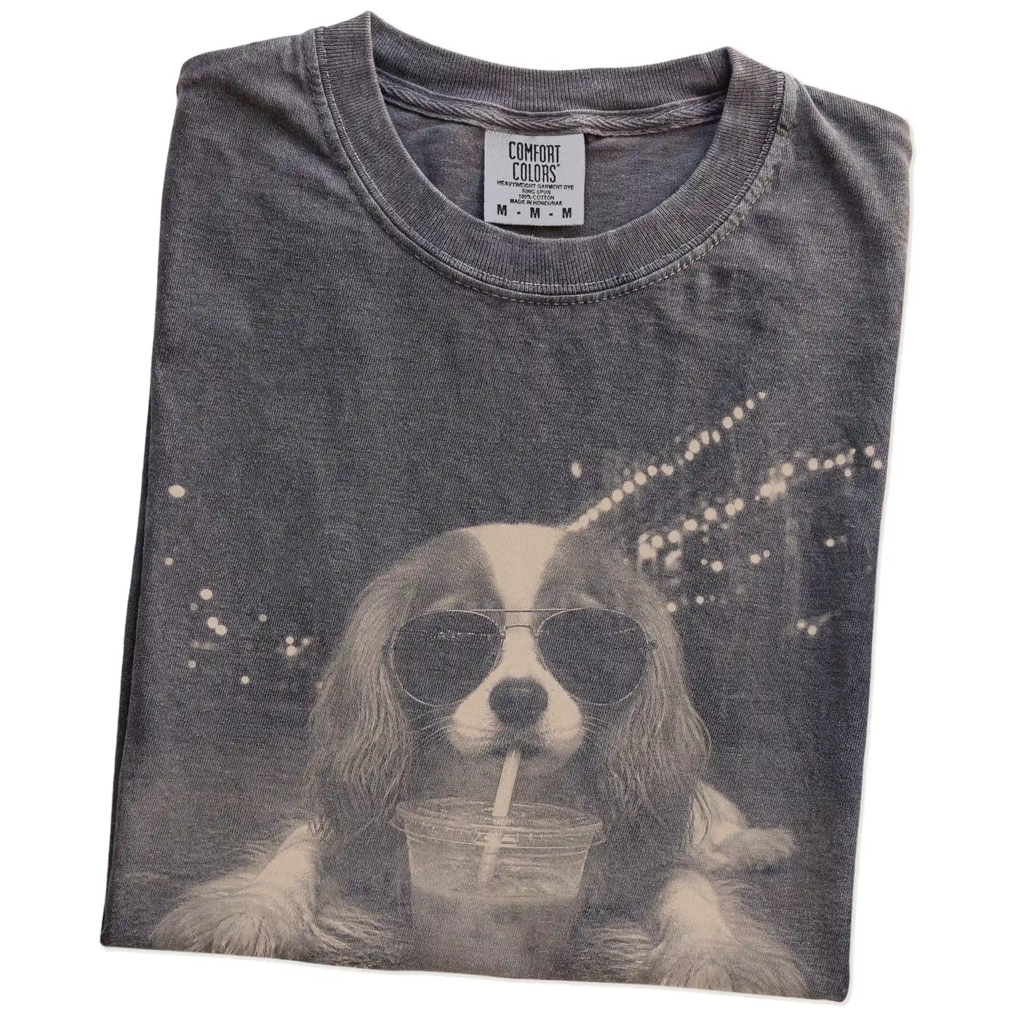 Folded Pepper Comfort Colors® T-shirt showing Cavalier King Charles Spaniel with iced coffee in a retro grunge design
