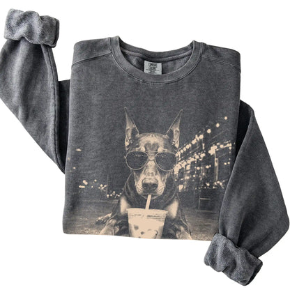 Doberman wearing aviator sunglasses and drinking iced coffee on a Pepper Comfort Colors 1566 Sweatshirt, folded view