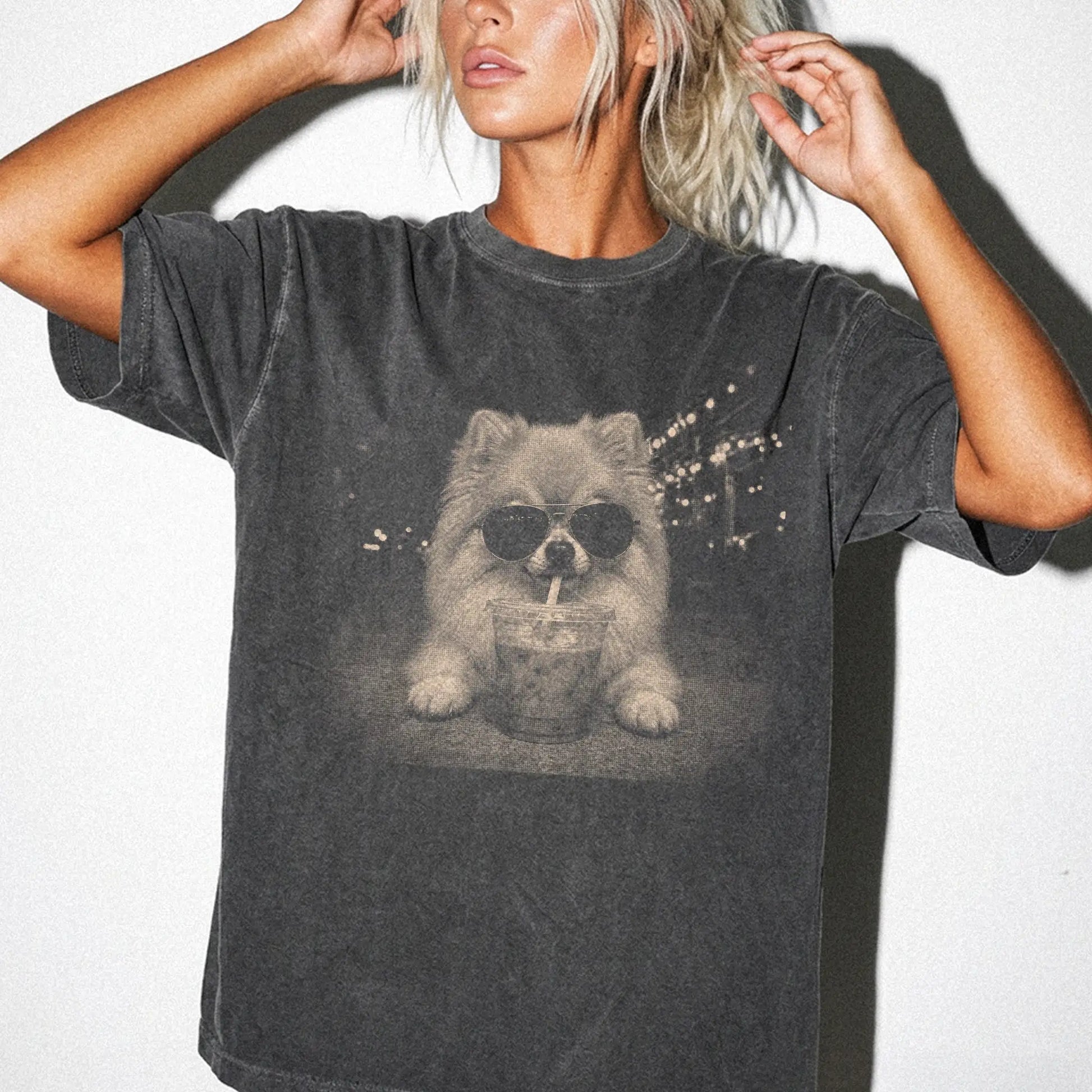 Model wearing a Pepper Comfort Colors® T-shirt featuring Pomeranian with iced coffee in a retro grunge design