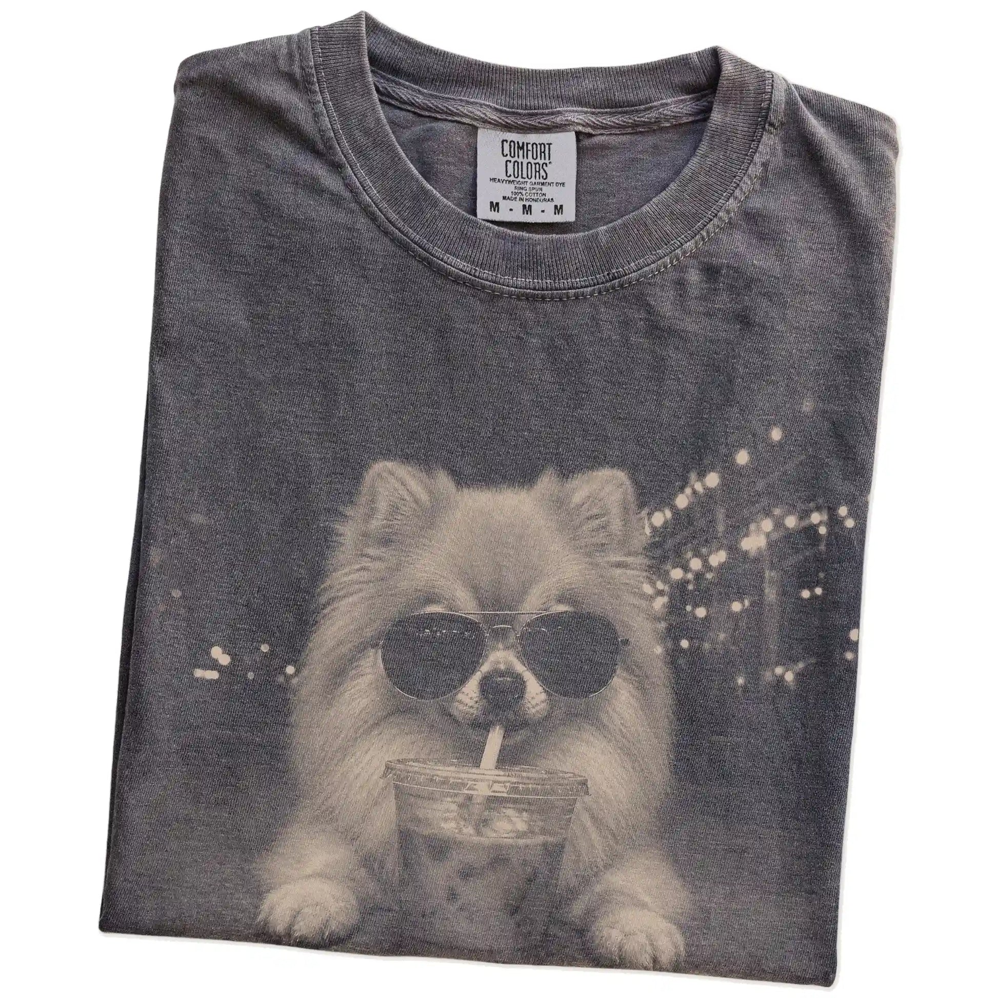 Folded Pepper Comfort Colors® T-shirt showing Pomeranian with iced coffee in a retro grunge design