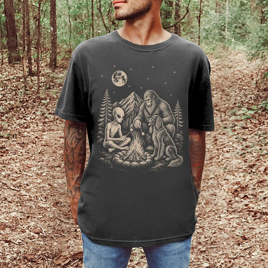 Model wearing a Pepper Comfort Colors® T-shirt showing Irish Setter camping with Bigfoot and an alien