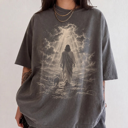 Person wearing a Pepper T-shirt with Jesus walking beside a Boston Terrier beneath rays of light