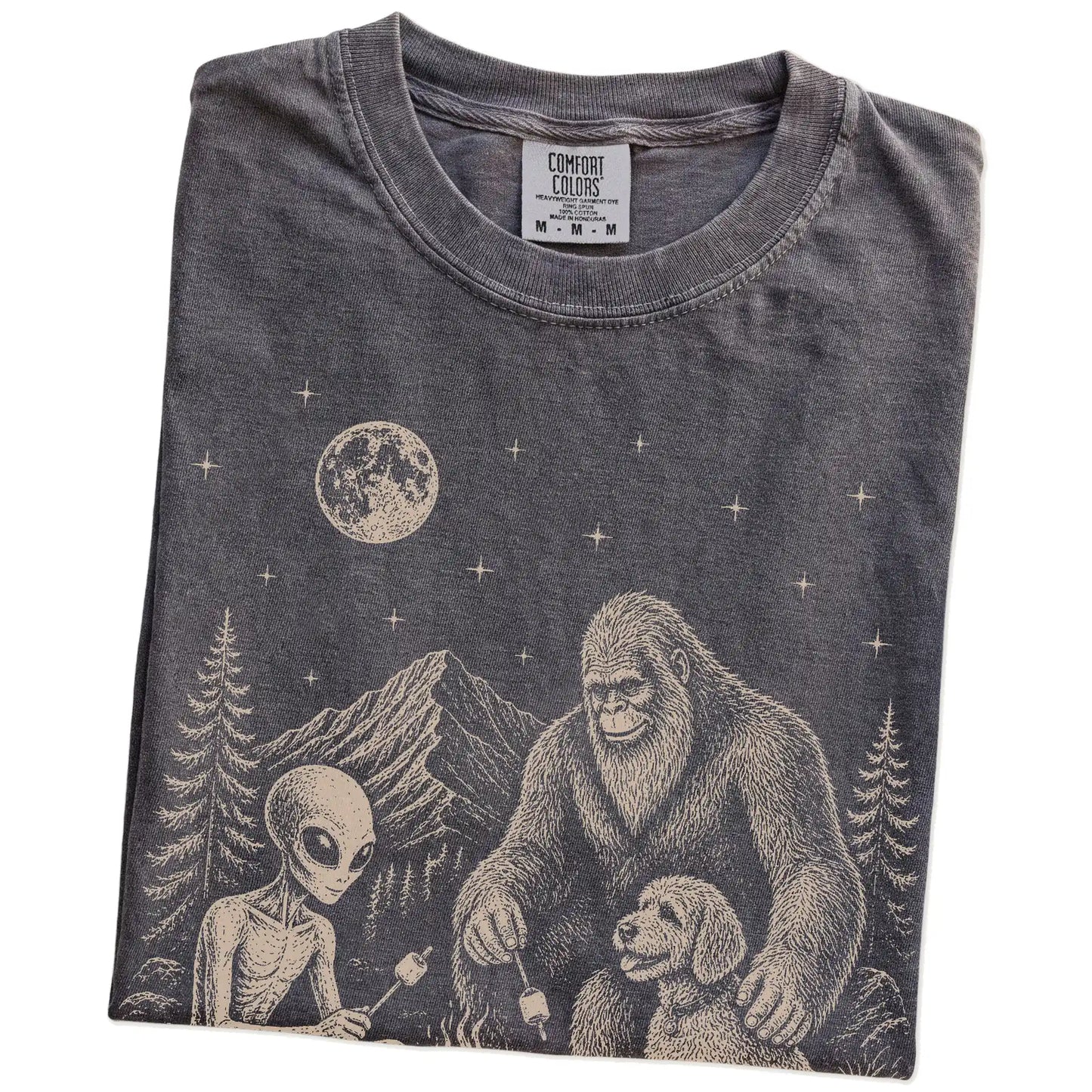 Folded Pepper Comfort Colors® T-shirt showing Labradoodle camping with Bigfoot and an alien