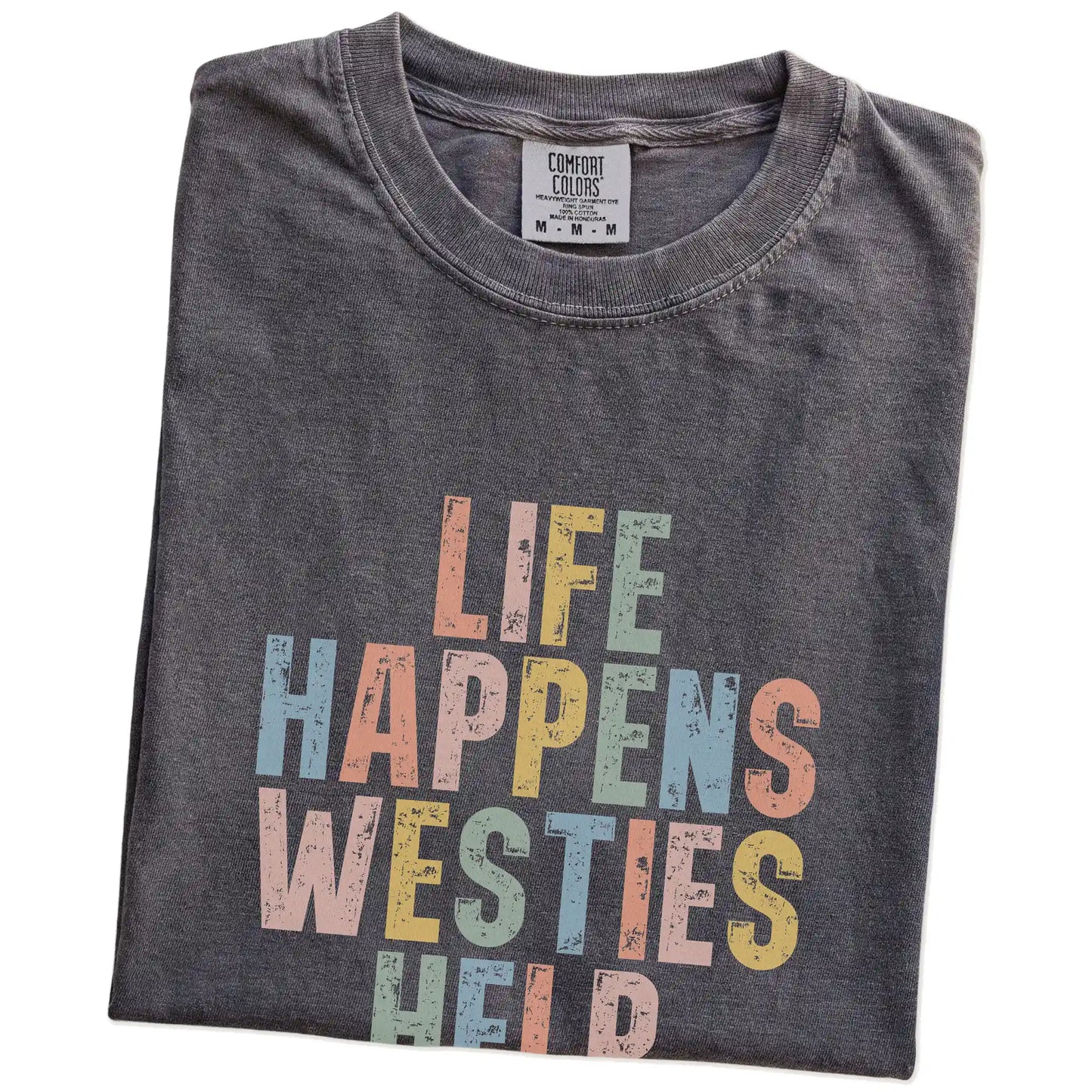 Folded Pepper Comfort Colors® T-shirt showing retro “Life Happens, Westies Help” lettering