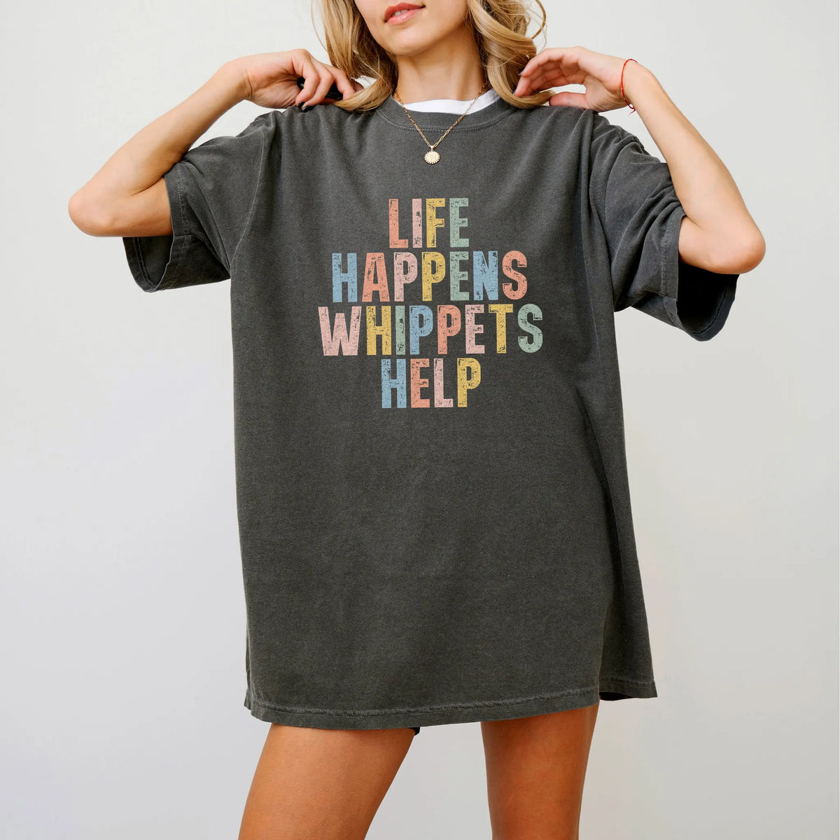 Model wearing a Pepper Comfort Colors® T-shirt featuring the “Life Happens, Whippets Help” saying
