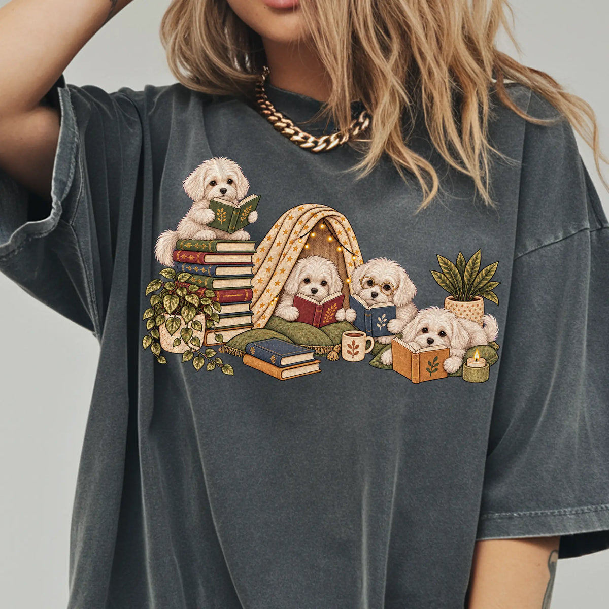 Maltese puppies reading books in a cozy blanket fort on a Pepper T-shirt worn by a model