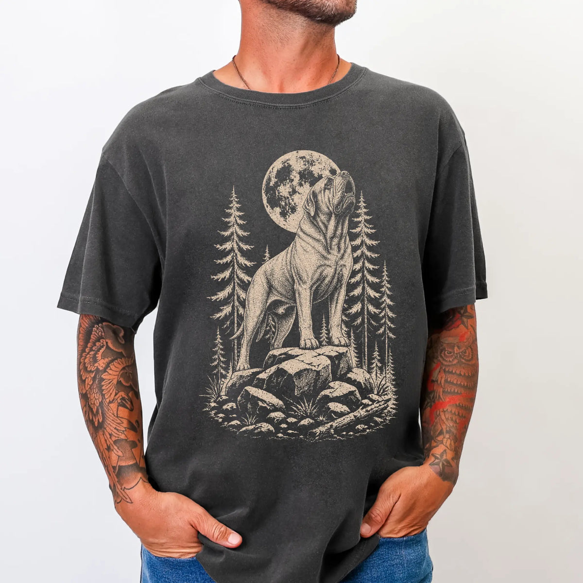 Model wearing a Pepper Comfort Colors® T-shirt with a Mastiff howling beneath the moon and pine trees