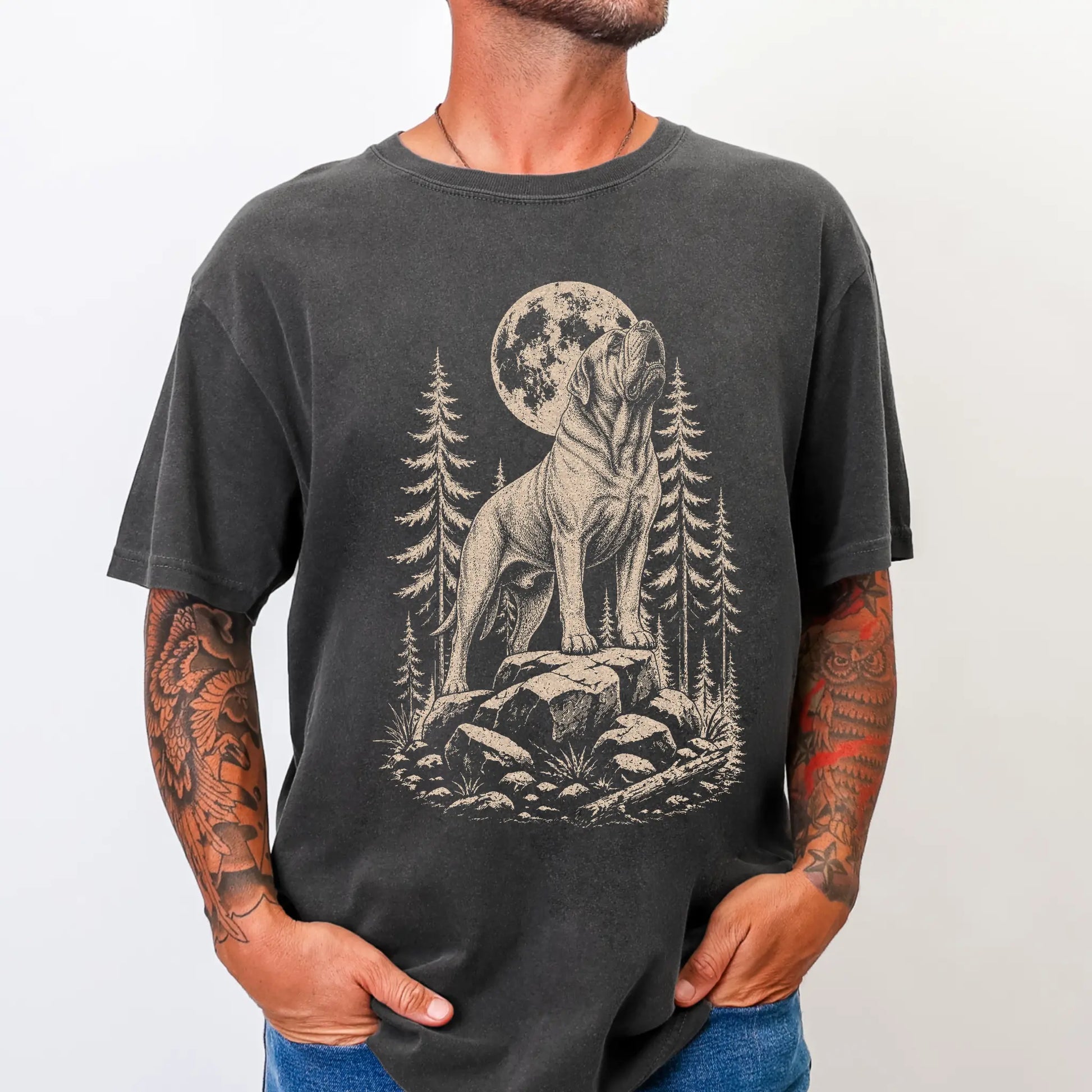 Model wearing a Pepper Comfort Colors® T-shirt with a Mastiff howling beneath the moon and pine trees