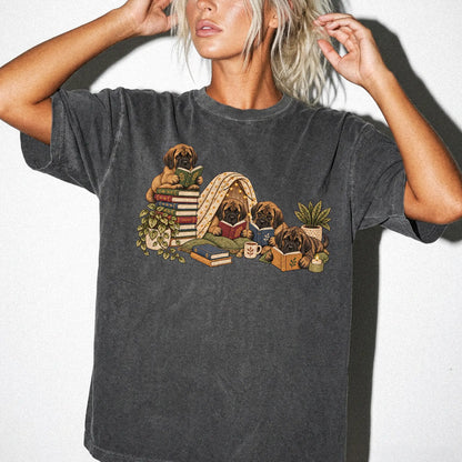 Mastiff puppies reading books in a cozy blanket fort on a Pepper T-shirt worn by a model