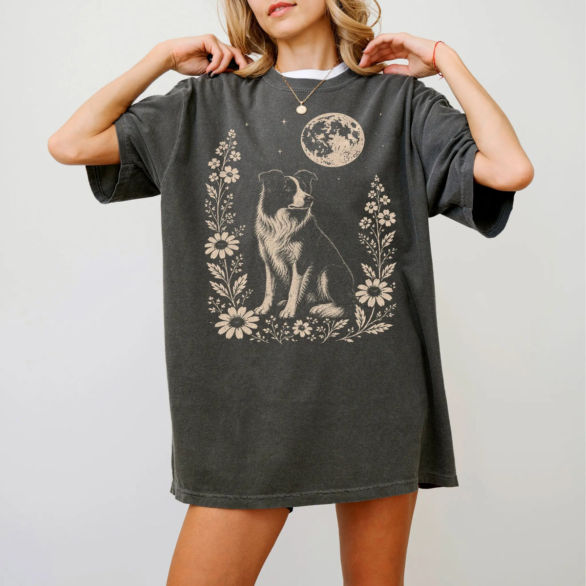 Model wearing a Pepper Comfort Colors® T-shirt featuring Border Collie framed by flowers beneath the moon