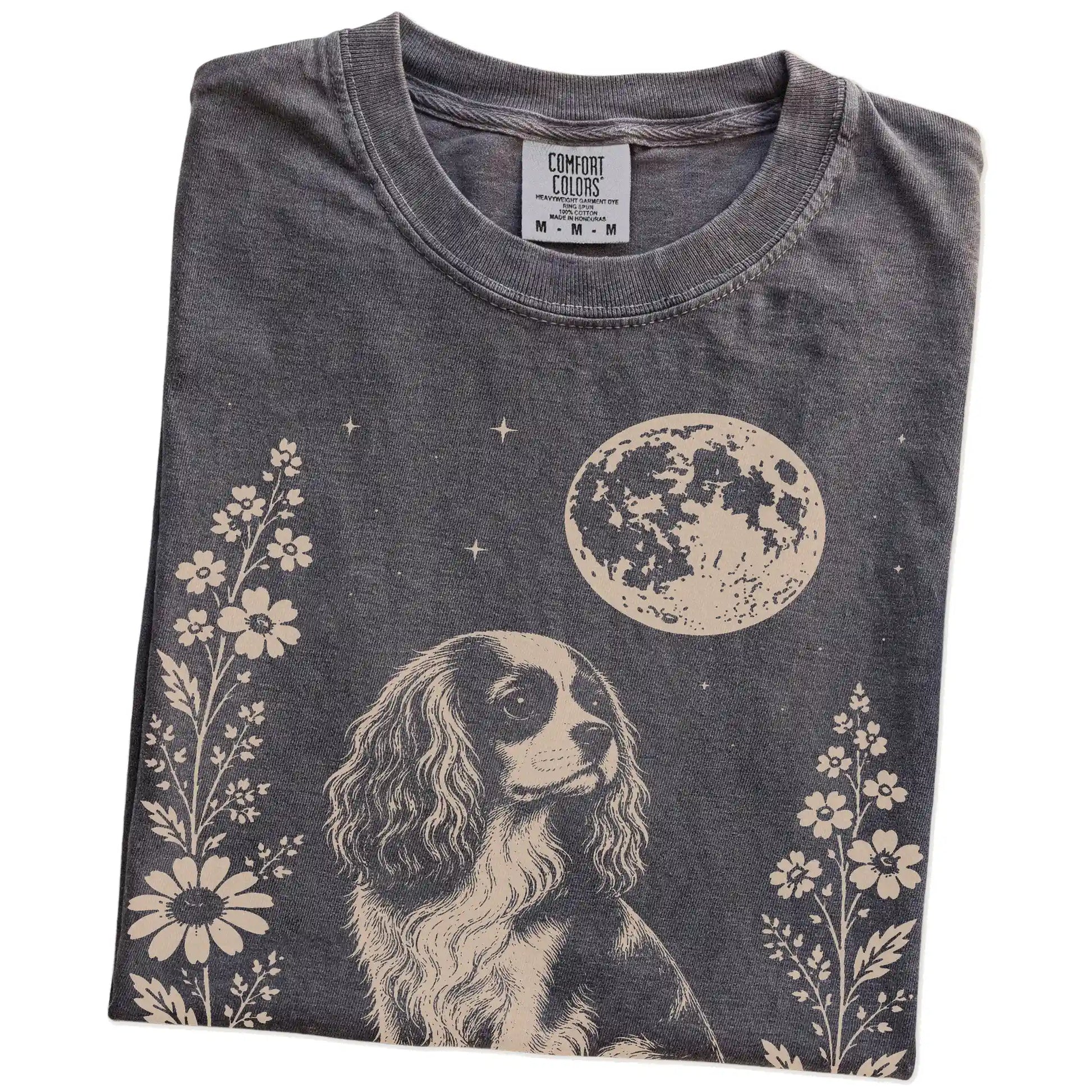 Folded Pepper Comfort Colors® T-shirt showing Cavalier King Charles Spaniel framed by flowers beneath the moon