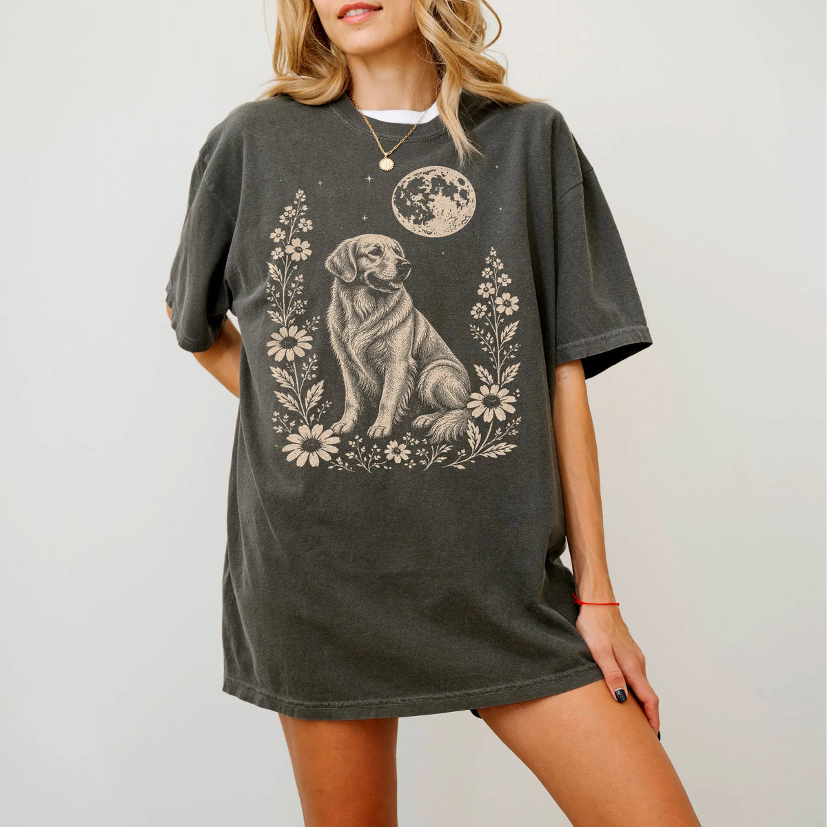 Model wearing a Pepper Comfort Colors® T-shirt featuring Golden Retriever framed by flowers beneath the moon