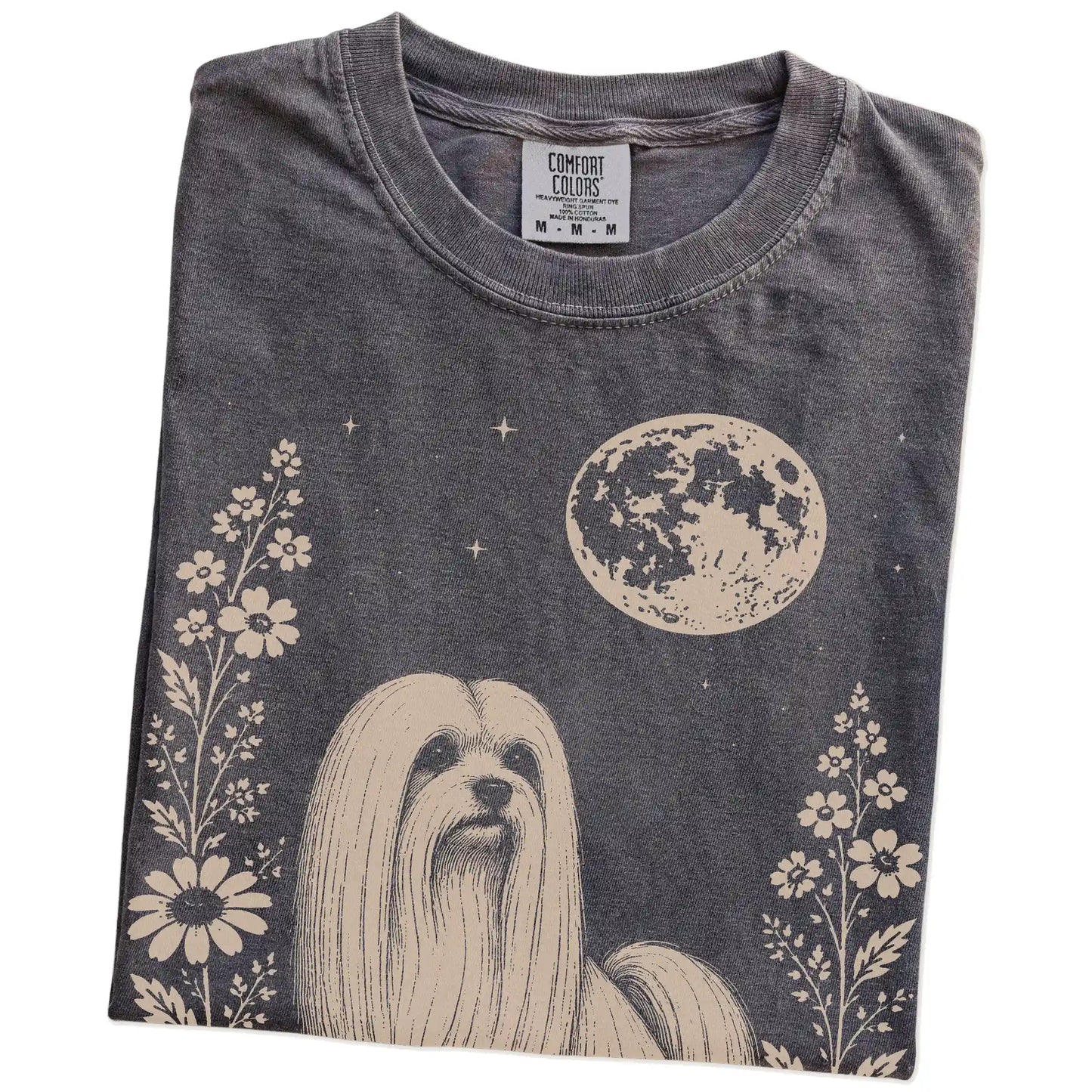 Folded Pepper Comfort Colors® T-shirt showing Maltese framed by flowers beneath the moon