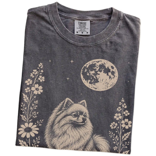 Folded Pepper Comfort Colors® T-shirt showing Pomeranian framed by flowers beneath the moon