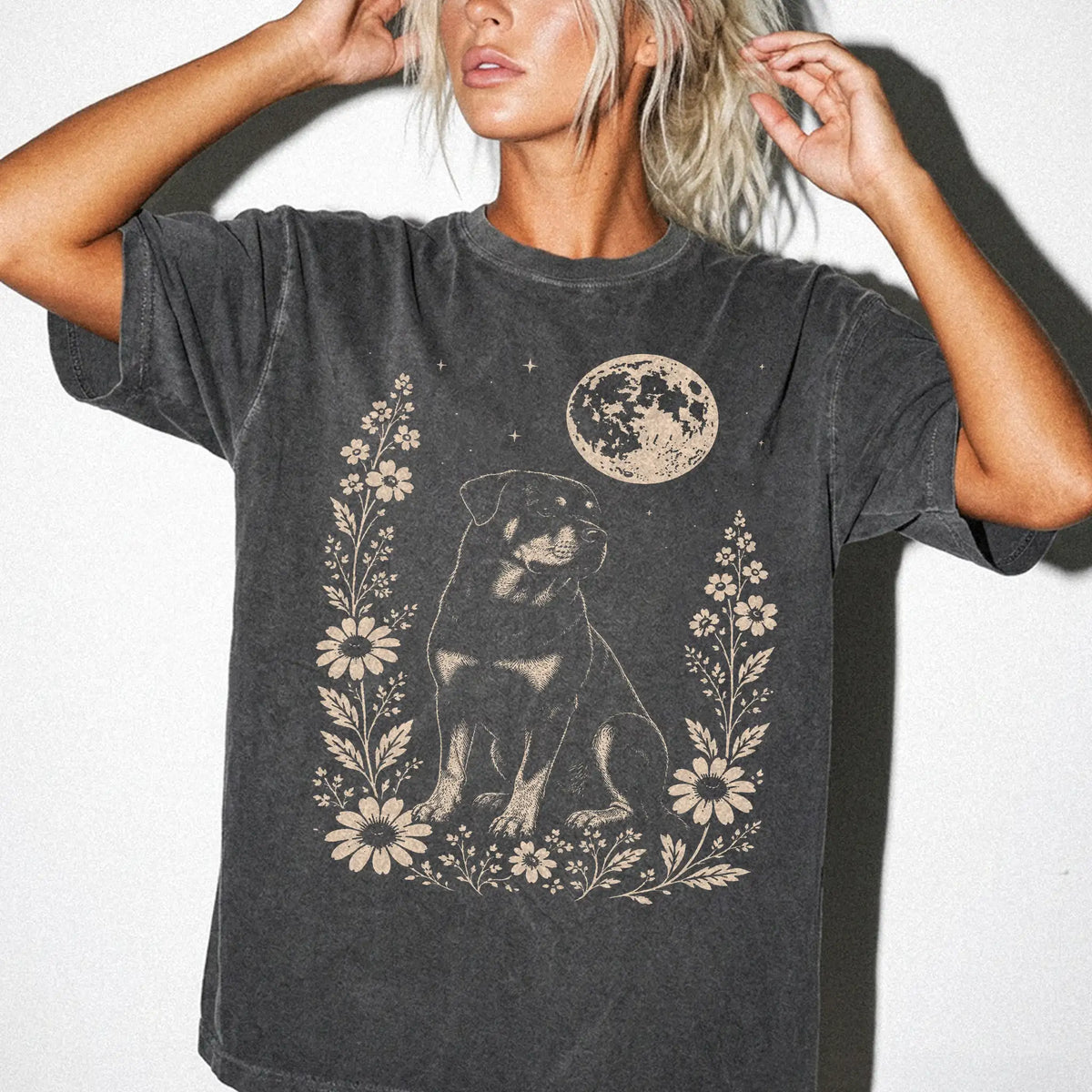 Model wearing a Pepper Comfort Colors® T-shirt featuring Rottweiler framed by flowers beneath the moon