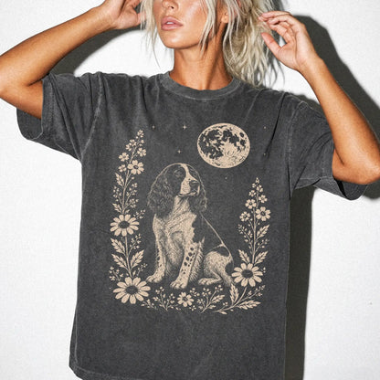 Model wearing a Pepper Comfort Colors® T-shirt featuring Springer Spaniel framed by flowers beneath the moon